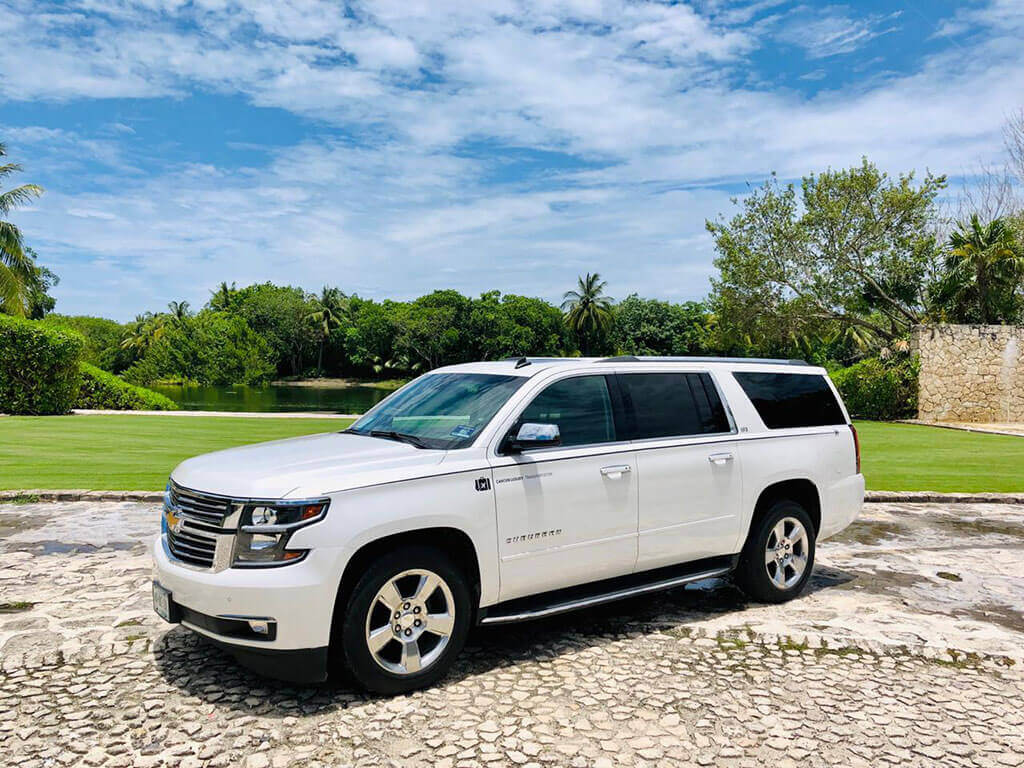 Luxury SUV parked by a lagoon and green area